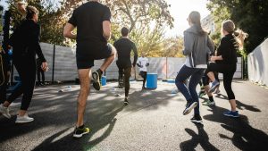 man in black t-shirt and black shorts running on road during daytime